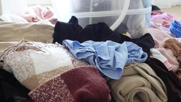 Sorting and organizing piles of clothes in a home setting video