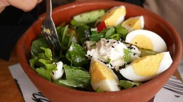 Fresh salad with eggs and herbs served in a rustic bowl video