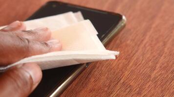 Cleaning a smartphone screen with a tissue in a cozy setting video