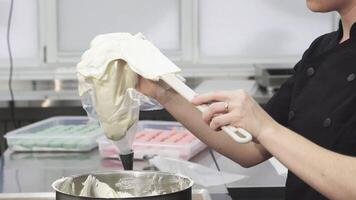 Confectioner expertly filling a pastry bag with creamy sour cream video
