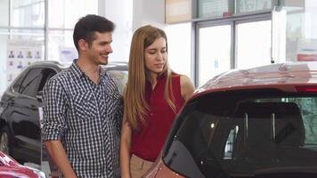 Charming couple exploring a sleek new automobile at the dealership video