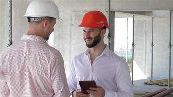 Construction engineer engages in discussion while holding a digital tablet video