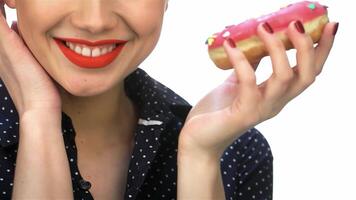 A delightful close-up of a charming pin-up girl with vibrant red lips, playfully holding a colorful donut adorned with sprinkles. Her retro hairstyle and joyful expression radiate a sense of fun and nostalgia, capturing the essence of vintage glamour video