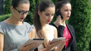 Three successful businesswomen engaged in calls and analyzing results video