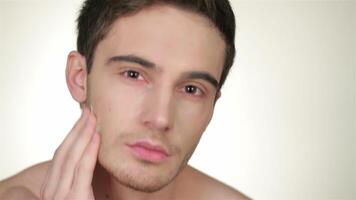 Handsome young man applying shaving foam with a thoughtful expression video
