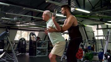 Trainer guides senior client through exercises for strength and balance video