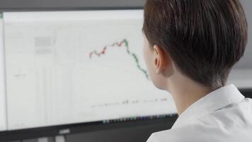 Focused woman analyzing stock rates on her computer video
