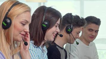 Dynamic team of young professionals in headsets collaborating at a call center video