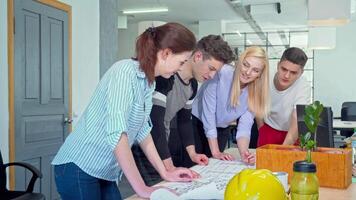 Dynamic young architects collaborating on a detailed blueprint in a modern office video
