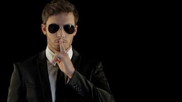 Confident bodyguard signals for silence with a finger to his lips video