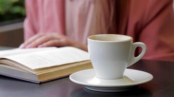 Cozy cafe scene with a book and a steaming cup of coffee video