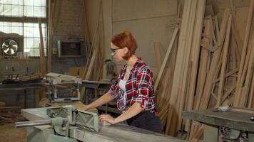 Focused female carpenter skillfully working with power tools in her vibrant workshop video