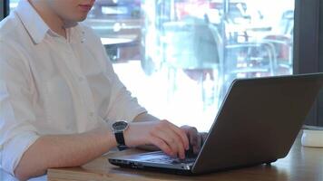 focado homem digitando em computador portátil dentro uma acolhedor cafeteria configuração video