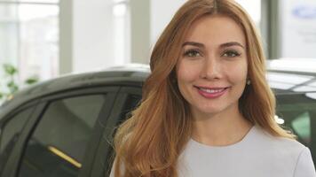 Cheerful attractive woman smiling while proudly displaying car keys at the dealership video