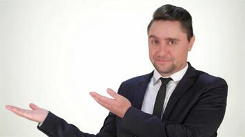 Confident young man in a suit pointing to copyspace with a charming smile video
