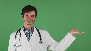 Cheerful male doctor smiling and presenting with open hand video