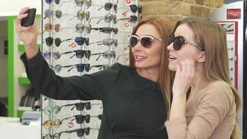 Gorgeous happy women taking selfies while shopping for eyewear video