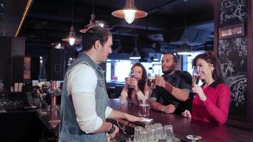 Three friends enjoying drinks and laughter at a lively bar video
