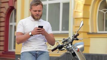 Young man enjoying a sunny day on his scooter while texting video