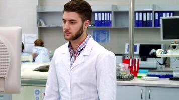 Focused scientist approaches the monitor in a modern laboratory video