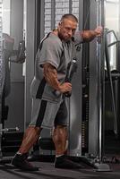 professional bodybuilder executes a cable exercise in a well equipped gym focusing on improving muscle tone and overall strength during an intensive training session photo