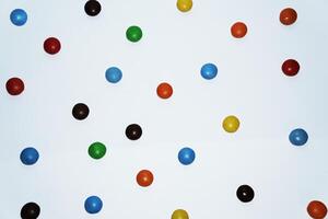 Scattered colorful candies on white background photo