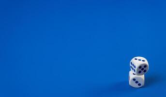 White dice stacked on top of each other against a vibrant blue background photo