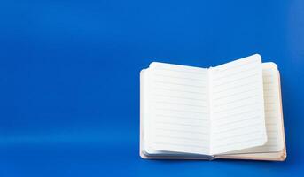 Open notebook with blank pages on a blue background photo