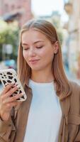 Beautiful young woman using smartphone typing text messages thinking and browsing internet on street video
