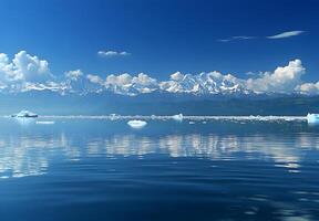 Majestic snow capped mountains reflected in a calm glacial lake photo