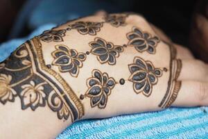 Beautiful henna design on hand with floral patterns and dots photo