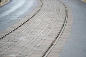 Curved tram tracks alongside a smooth avenue in a city setting photo
