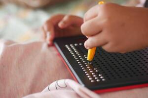 Child engaged in creative activity with a dot-matrix board at home photo