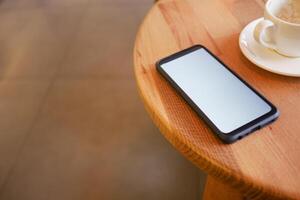 Relaxing coffee break with a smartphone on the table photo