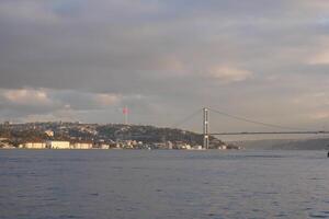 Bosphorus view with bridge and Turkish flag at twilight photo