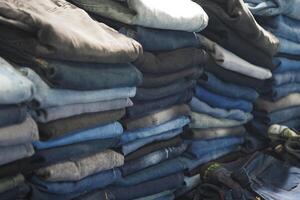 Neatly stacked denim jeans in varied shades at a retail store photo