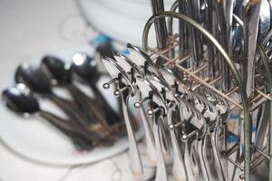 Silver utensils neatly arranged in a kitchen setting for dining photo