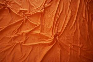 Bright orange fabric draped with natural folds and creases photo