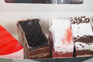 Assorted slices of colorful cakes displayed in a box photo