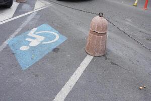 Concrete barrier blocks access to handicapped parking space on street photo