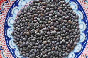Black gram beans displayed on colorful patterned plate photo