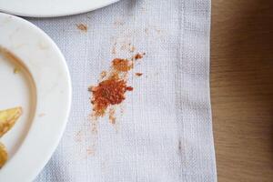 Spill on a tablecloth near empty plates after a hearty meal gathering photo