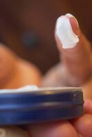 Moisturizing cream application on fingertip in close-up view photo