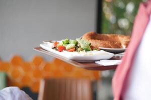 Freshly prepared plate with salad and bread in a cozy cafe setting photo