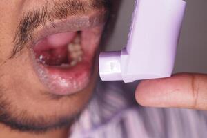 Using an inhaler for asthma relief during evening hours photo