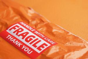 Orange package with fragile label ready for careful handling photo