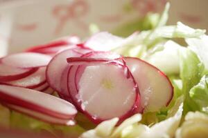 Freshly sliced radishes on a bed of crisp lettuce for a healthy salad photo