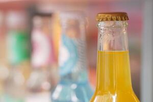 Refreshing beverages in clear glass bottles on display in market photo