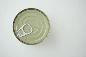 Metal can with pull tab on a plain surface in bright lighting photo