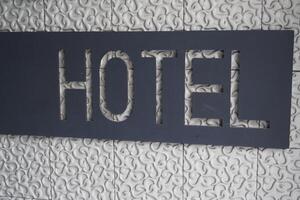 Modern hotel signage displayed on textured wall surface photo